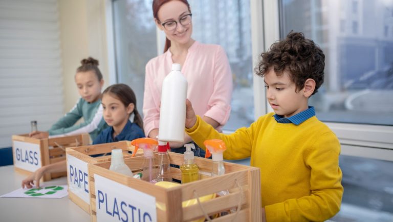 Children recycling glass, paper, and plastic.