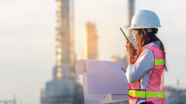 A worker talking through a radio and holding a map